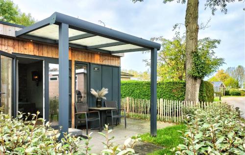 a blue shed with a table in a yard at Stunning Apartment In Heinkenszand in Heinkensand