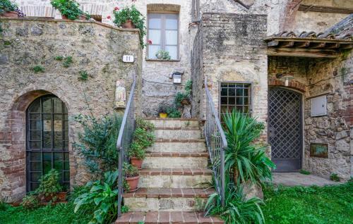 an old stone building with stairs and plants at Awesome Apartment In Monticiano in Monticiano