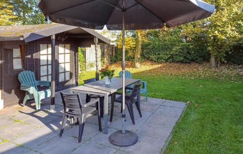 un tavolo in legno con sedie e ombrellone di Pet Friendly Home In Heinkenszand a heinkenszand
