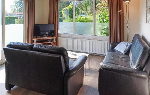 un soggiorno con 2 sedie in pelle e una TV di Pet Friendly Home In Heinkenszand a heinkenszand