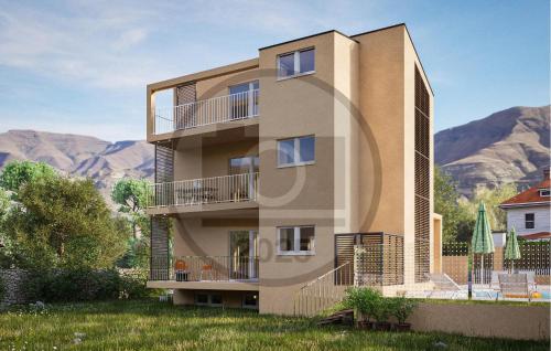 un edificio alto con montañas en el fondo en Nice Apartment In Starigrad Paklenica, en Starigrad-Paklenica