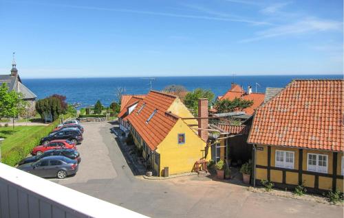 a group of cars parked in a parking lot next to houses at Stunning Apartment In Gudhjem in Gudhjem