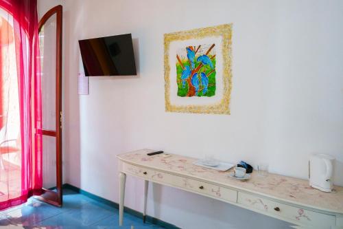 a room with a table and a painting on the wall at Hotel Villa Belfiori in Torre Dei Corsari