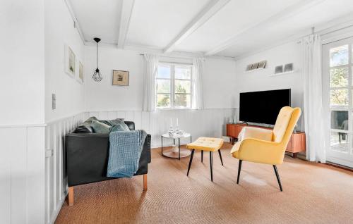 a living room with a couch and chairs and a tv at 3 Bedroom Amazing Home In Væggerløse in Marielyst