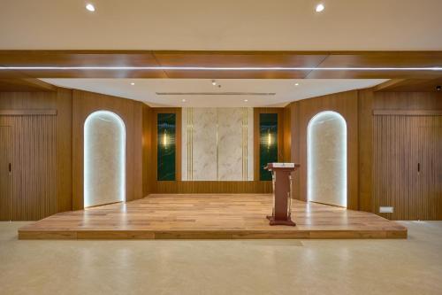 a large room with a podium in the middle of a stage at Kowju Airport Hotel Calicut in Kondotti
