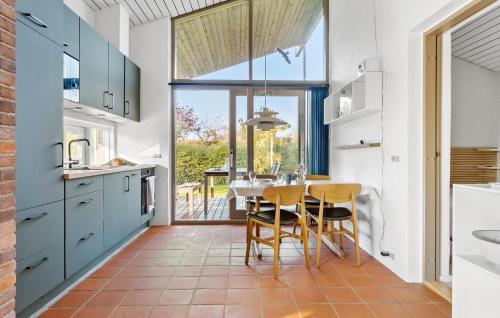a kitchen with blue cabinets and a table with chairs at Stunning Home In Vordingborg With Wifi in Vordingborg