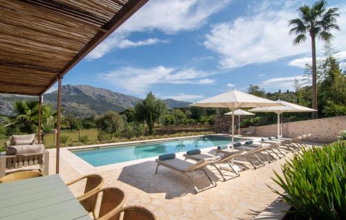 a pool with chairs and umbrellas in a resort at Can Guillem-Bet in Pollença