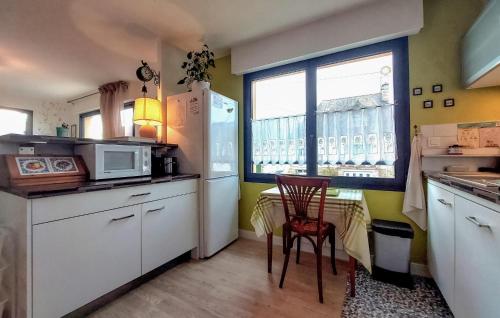une cuisine avec des appareils blancs, une table et une fenêtre dans l'établissement Nice Apartment In Saint-Malo With Wifi, à Saint-Malo