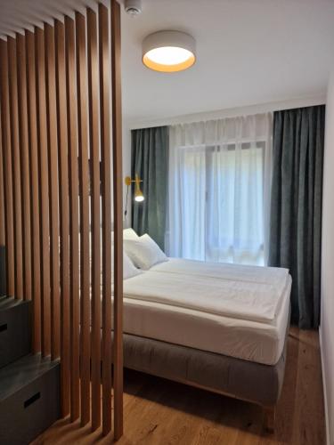 a bedroom with a bed and a large window at Apartmán Ski & Bike Janské Lázně in Janske Lazne