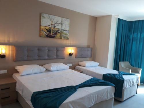 Una habitación de hotel con dos camas y un cuadro en la pared. en Asım ve nurhan kocabıyık öğretmenevi, en Avcılar