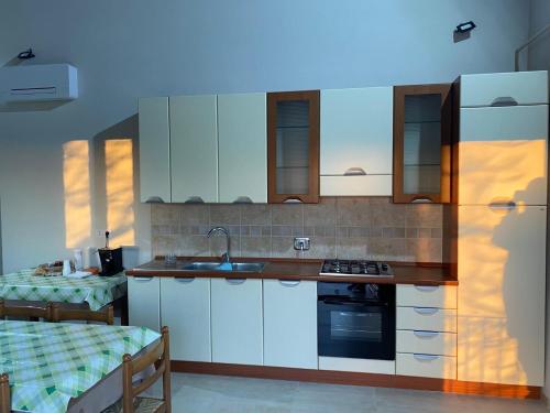 a kitchen with white cabinets and a sink at Antica Masseria Lo Conte in Ariano Irpino