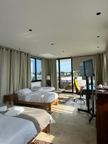 a hotel room with two beds and a flat screen tv at Dar Souad in La Marsa