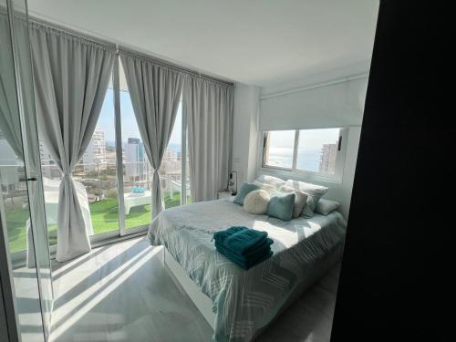 een slaapkamer met een bed en een groot raam bij Loft beach in Alicante