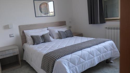 a bedroom with a large bed with white sheets and pillows at B&B Bella Peschici in Peschici