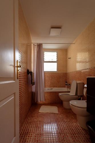 a bathroom with a toilet and a tub and a sink at Apartment happy place mit Meerblick in Alcalá