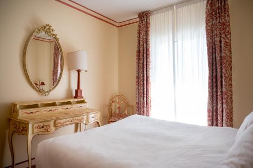 a bedroom with a bed and a mirror and a window at DB Villas Le Ville del Lido Resort in Venice-Lido