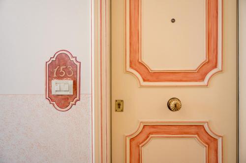 a door with a clock on the side of it at DB Villas Le Ville del Lido Resort in Venice-Lido