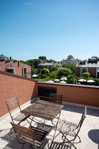 two chairs and a table on a patio with a brick wall at DB Villas Le Ville del Lido Resort in Venice-Lido