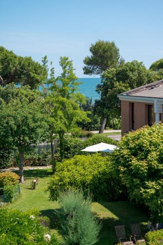 a garden with trees and a house and the ocean at DB Villas Le Ville del Lido Resort in Venice-Lido