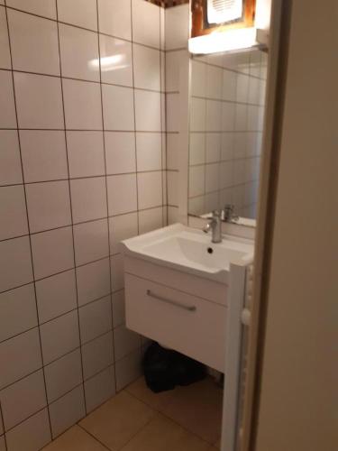 une salle de bain blanche avec un lavabo et un miroir dans l'établissement Paul a 12 km de la mer, à Roquebrune-sur Argens