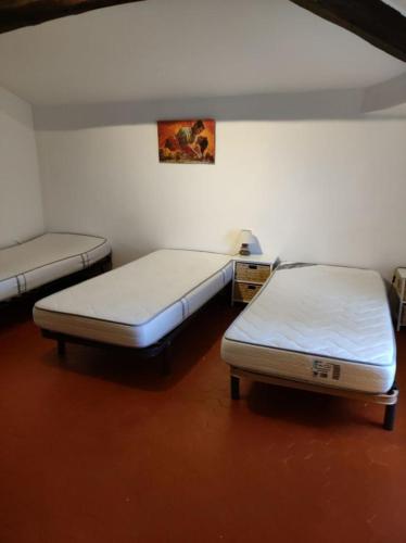 - 2 lits jumeaux dans une chambre dotée de sols rouges dans l'établissement Paul a 12 km de la mer, à Roquebrune-sur Argens