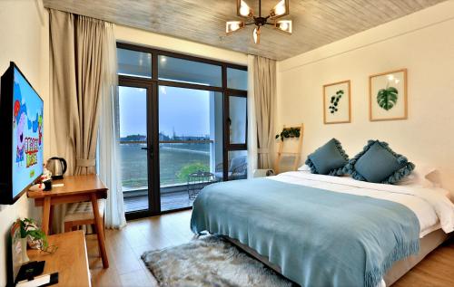 a bedroom with a large bed and a large window at 上海乡韵亲子酒店 in Shanghai
