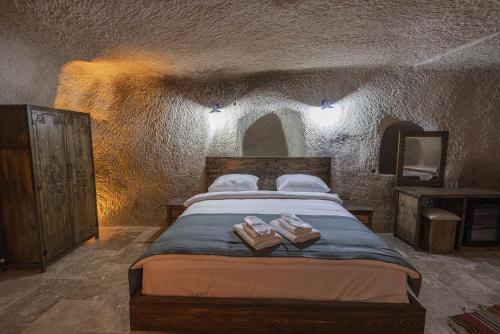 a bedroom with a large bed in a stone wall at Kayaharman cave otel in Nar