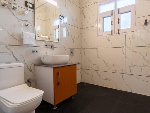 une salle de bain avec toilettes, lavabo et miroir dans l'établissement Moustache Srinagar, à Srinagar