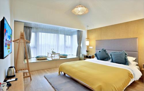 a bedroom with a large bed and a window at 上海乡韵亲子酒店 in Shanghai