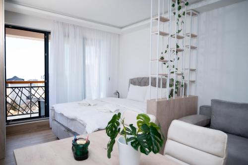 Un dormitorio blanco con una cama y un sofá. en Residence Hill A036 Apartment, en Kopaonik