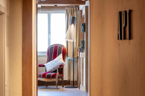 a room with a red chair and a window at Hotel Kreuz & Post Grindelwald in Grindelwald