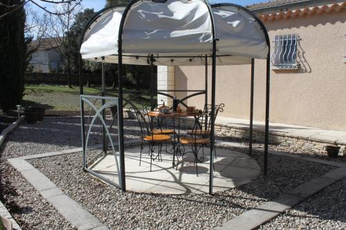 ヴィルヌーヴ・ド・ベルグにあるChambres d'hôtes Des couleurs et des Motsのガゼボ(テーブルと椅子付)