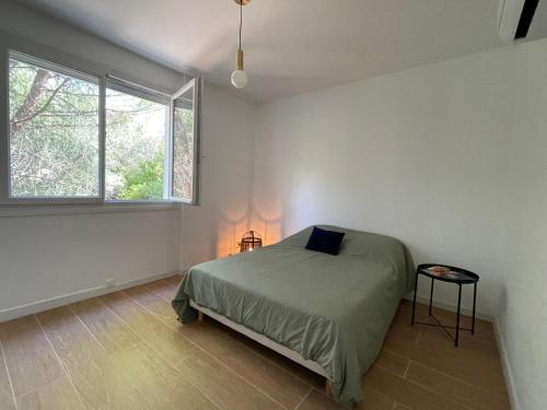 Le Nid D'Aiguelongue Parking Wifi Climatisation Terrasse في مونبلييه: غرفة نوم بها سرير ونافذة