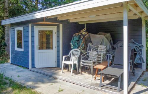 a blue shed with chairs and tables on a patio at Stunning Apartment In Dannenberg Elbe in Besenberg