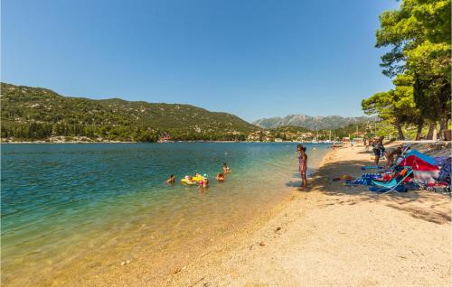 a group of people in the water at a beach at Two-Bedroom Apartment In Ploce in Ploče