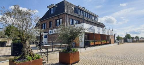 a brick building with two trees in front of it at Sientjes Boetiekhotel in Kerkdriel