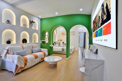 a living room with a couch and a green wall at 上海乡韵亲子酒店 in Shanghai