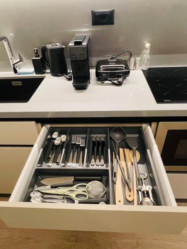 a kitchen drawer filled with utensils on a counter at Two Steps Apartments Tirana in Tirana