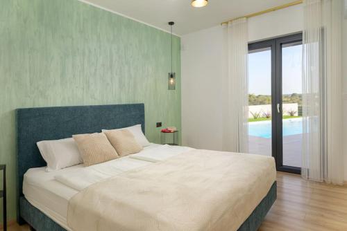 a bedroom with a large bed and a pool at Villa Drandic by IstriaLux in Bale