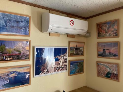 a wall with a air conditioner on a wall with pictures at Guest house mochilero onomichi in Onomichi