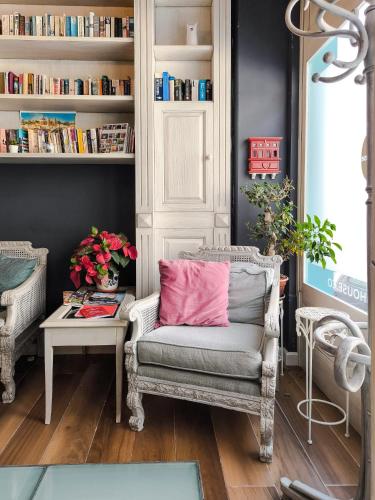 a room with a chair with a pink pillow at D Townhouse Boutique Suites in Sliema