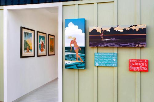 a group of pictures on a wall in a room at Kauai Shores Hotel in Kapaa