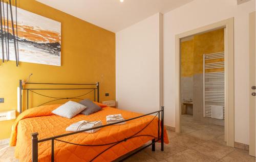 a bedroom with a bed with an orange bedspread at Amazing Home In Morrovalle With Wifi in Morrovalle