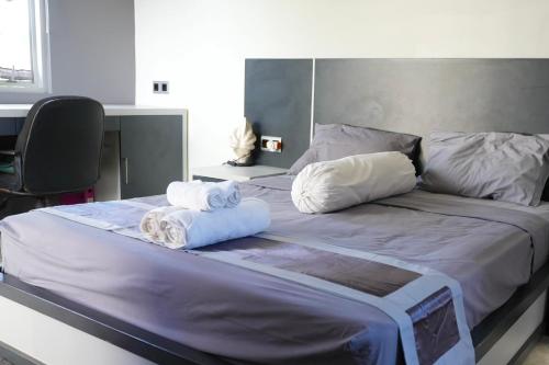 a large bed with two rolled towels on it at Villa Rumah Putih Abu Abu in Senggigi 