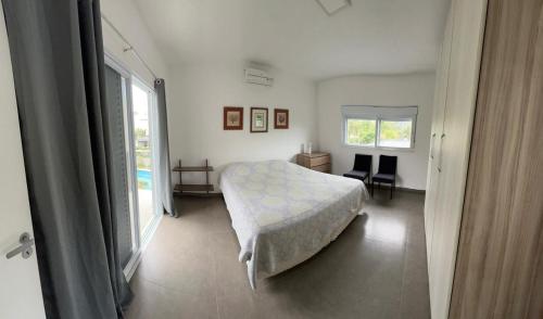 a bedroom with a bed and a large window at Casa em condomínio fechado, ambiente familiar in São Sebastião