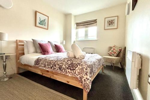 a bedroom with a bed with pink and white pillows at Stunning 2 Bed Ensuite Apart in London