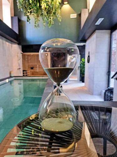 an hourglass sitting on a table next to a pool at Brit Hotel Les Voyageurs in Loudéac