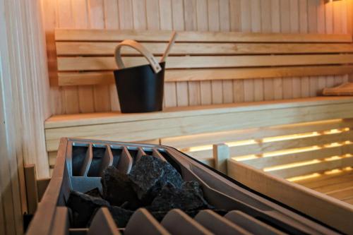 a tub with a bin of charcoal in a sauna at Brit Hotel Les Voyageurs in Loudéac