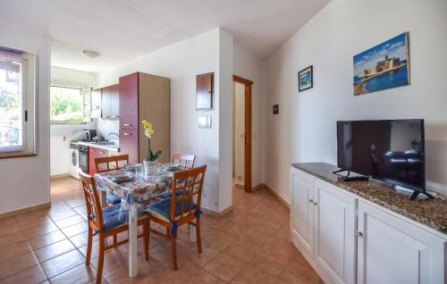 a kitchen and dining room with a table and a television at 1 Bedroom Amazing Apartment In Staletti in Stalettì