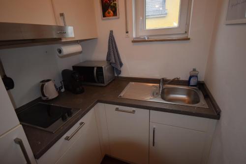 a small kitchen with a sink and a microwave at Nestwerk Clever R23-14 - Arbeiten, Erholen & Zentrumsnah in Biberach an der Riß